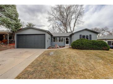 Charming gray home featuring an attached garage, complemented by a well-maintained front yard and walkway at 5271 S Logan St, Littleton, CO 80121