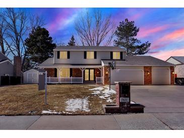 Charming two-story home with a well-manicured lawn, inviting front porch and attached two car garage at 7631 Oak St, Arvada, CO 80005