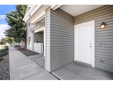 Inviting front entrance with white door and neutral siding on a well-maintained home at 905 S Zeno Way # 204, Aurora, CO 80017