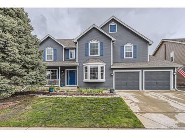 Charming two-story home with a manicured lawn, blue accents, and a spacious two-car garage at 8862 Chestnut Hill Ln, Highlands Ranch, CO 80130