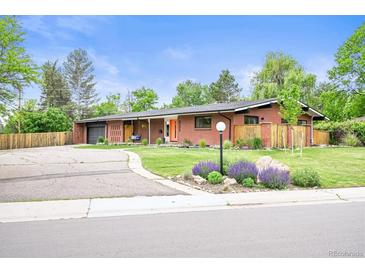 Charming red brick home with landscaped yard, bright orange door and attached garage at 5200 W Rowland Ave, Littleton, CO 80128