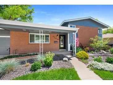 Charming single-story brick home with a cozy porch and beautifully landscaped front yard at 6040 Taft Ct, Arvada, CO 80004