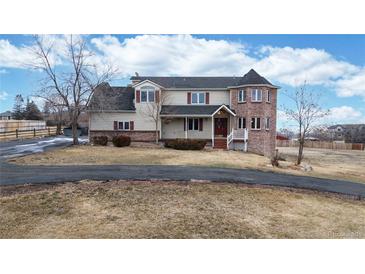 Charming two-story home with brick turret and welcoming front porch on a large lot at 7208 Secrest Ct, Arvada, CO 80007