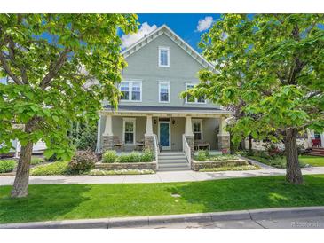 Charming two-story home with light-green siding, inviting front porch, and professionally landscaped front yard at 3212 Fulton St, Denver, CO 80238
