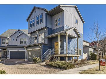 Modern two-story home featuring blue siding, a covered porch, and an attached garage at 5188 Andes Way, Denver, CO 80249