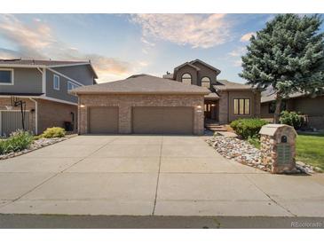 Charming two-story home featuring a brick facade, three-car garage, and well-maintained landscaping at 1123 Oakhurst Dr, Broomfield, CO 80020