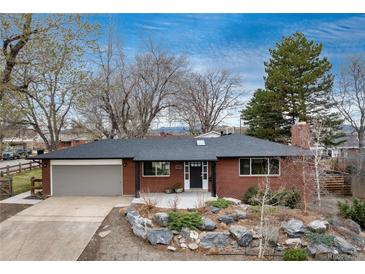 Charming brick home with landscaped front yard, mature trees and a two-car garage at 5743 Field St, Arvada, CO 80002