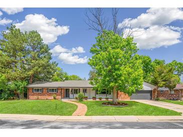 Charming ranch-style home with brick accents, lush lawn, and a brick walkway leading to the front door at 423 Nile St, Aurora, CO 80010