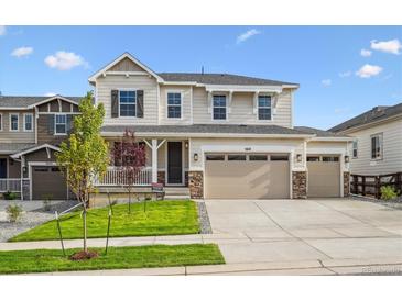 Beautiful two-story home with a three-car garage and well-manicured lawn on a sunny day at 5614 Riverbend Ave, Firestone, CO 80504