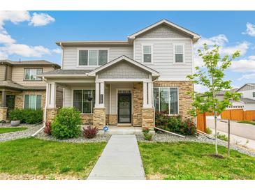 Charming two-story home with a stone-accented facade, inviting front porch and beautifully landscaped front yard at 11761 Cord Grass Way, Parker, CO 80138