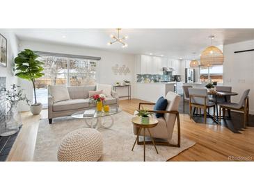 Bright living room featuring contemporary furnishings, wood floors, and a large window with snow-covered outdoor views at 3091 S Krameria St, Denver, CO 80222