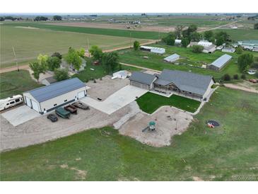 Stunning aerial view of a farmhouse with spacious garage and recreational area at 6331 County Road 32, Platteville, CO 80651