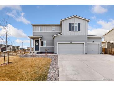 Charming two-story home with a three-car garage, gray siding and well-maintained landscaping at 2405 Horse Shoe Cir, Fort Lupton, CO 80621