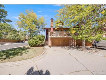 Charming two-story home featuring a balcony, multi-car garage, and mature trees creating a welcoming curb appeal at 1810 Youngfield Ct # A, Golden, CO 80401