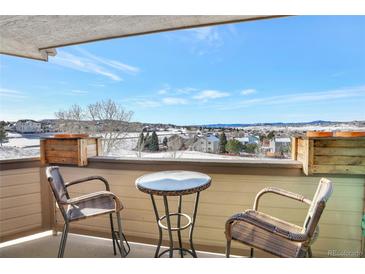 Cozy balcony seating offers a serene view of the surrounding snow-covered landscape and bright blue sky at 920 E Plum Creek Pkwy # 306, Castle Rock, CO 80104