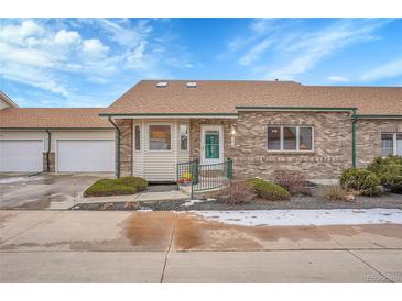 Charming single story brick home featuring an attached two car garage and manicured front yard at 2616 E Egbert St, Brighton, CO 80601