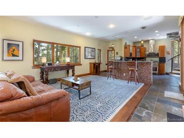 Open-concept living room flows into the kitchen, with hardwood flooring and exposed beams at 167 Independence Cir, Breckenridge, CO 80424