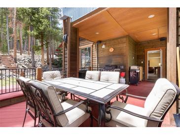 Outdoor patio with dining table, grill, and views of the surrounding forest at 167 Independence Cir, Breckenridge, CO 80424