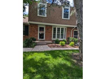Charming two-story brick home with a well-manicured lawn and lush landscaping at 9060 E Cherry Creek South Dr # E, Denver, CO 80231
