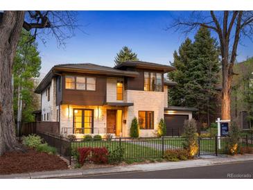 Beautifully landscaped two-story home featuring stone and wood facade, manicured lawn, and black metal fencing at 424 Grape St, Denver, CO 80220