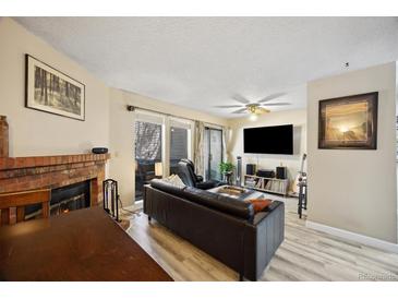 Comfortable living room with a fireplace, patio access, and entertainment center at 12354 W Nevada Pl # 102, Lakewood, CO 80228