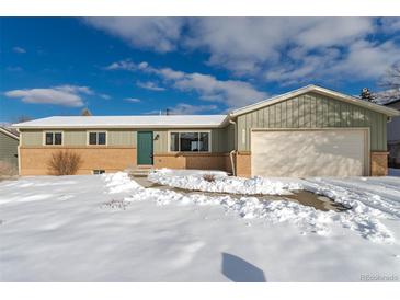 Charming single-Gathering home featuring a well-maintained lawn, attached garage, and classic brick accents at 6526 S Cherry Way, Centennial, CO 80121