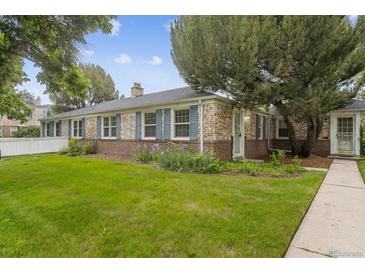 Charming brick home with blue shutters and a well-manicured lawn at 1279 Leyden St, Denver, CO 80220