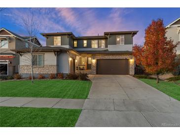 Charming two-story home featuring stone accents, a spacious driveway, and a well-manicured lawn at 515 Orion Ave, Erie, CO 80516