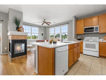 Bright kitchen with a center island, a cozy fireplace, and stainless steel appliances at 7130 Simms St # 206, Arvada, CO 80004