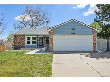 Charming single-Gathering home featuring a brick and blue facade, a well-manicured lawn, and a two-car garage at 17476 E Bellewood Cir, Aurora, CO 80015