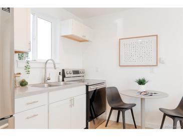 Bright kitchen features stainless steel appliances, white cabinets and gray countertops at 3903 W Nevada Pl, Denver, CO 80219