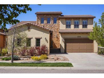 Beautiful two-story home with stone accents, a two-car garage, and a well-manicured lawn at 15179 W Washburn Ave, Lakewood, CO 80228