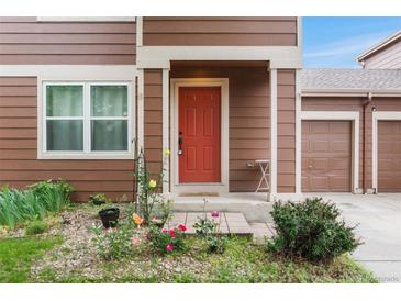 Inviting front door with small porch, colorful garden and meticulous landscaping at 5168 Goshawk St, Brighton, CO 80601