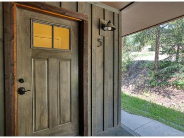 Rustic wood front door with glass pane, house number, and exterior light fixture at 166 S Fuller Placer Rd # 5, Breckenridge, CO 80424