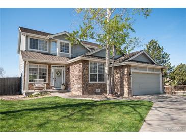Charming two-story home with stone accents, manicured lawn, and a welcoming front porch at 9684 W Long Dr, Littleton, CO 80123
