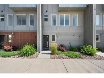 Modern townhome exterior highlighting clean lines, multiple windows, and tidy landscaping along a sidewalk at 8711 E Hampden Ave # 6, Denver, CO 80231