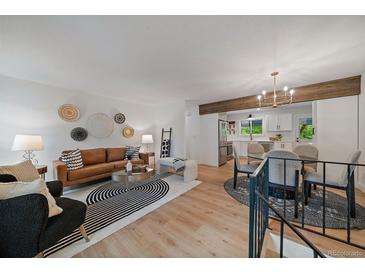 Bright living room featuring a modern design, hardwood floors, and seamless flow into the adjacent kitchen at 116 Monarch St, Louisville, CO 80027