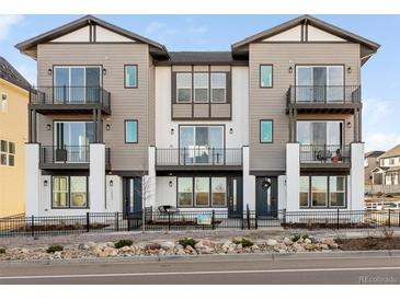 Modern three-story townhome with balconies and a landscaped front yard at 3109 W Bates Ave, Denver, CO 80236