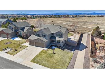 Stunning two-story home with a well-manicured lawn and inviting front porch and attached two car garage at 1537 Rosedale St, Castle Rock, CO 80104