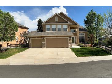 Charming two-story home featuring a three-car garage and well-manicured lawn at 22302 Quail Run Way, Parker, CO 80138