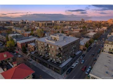 Stunning aerial view of a modern apartment building with private balconies, showcasing the city skyline at sunset at 1300 N Ogden St # 304, Denver, CO 80218