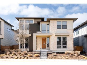 Modern home featuring stone accents, a stylish front door, and professionally landscaped front yard at 6021 N Boston Ct, Denver, CO 80238