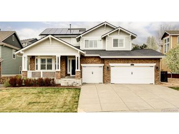 Charming two-story home with a stone facade, solar panels, and an attached two-car garage at 6103 S Millbrook Ct, Aurora, CO 80016