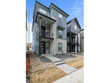 Beautiful modern home with stone accents, a covered porch, and professionally landscaped front yard at 16605 Peak St, Broomfield, CO 80023