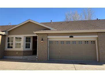 Charming home featuring a neutral color palette, brick accents, and an attached garage with carriage-style doors at 15346 Heritage Cir, Thornton, CO 80602