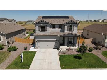 Charming two-story home with a well-maintained front yard, two-car garage, and solar panels on the roof at 7414 Blue River Ave, Frederick, CO 80530
