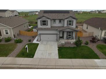 Beautiful two-story home featuring solar panels, a well-manicured lawn, and an attached two car garage at 7414 Blue River Ave, Frederick, CO 80530