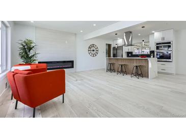 Bright living room featuring a modern fireplace, breakfast bar, and an open floor plan at 2582 S Birch St, Denver, CO 80222