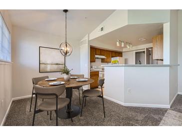 Dining area featuring modern light fixture, room to entertain and open floorplan at 5705 N Genoa Way # 308, Aurora, CO 80019