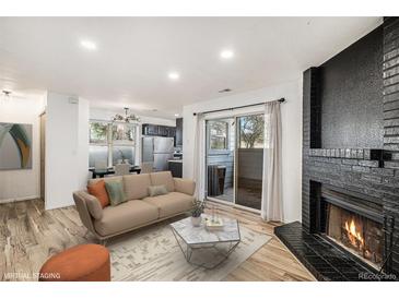 Inviting living room with a cozy fireplace and sliding glass doors to the outdoor patio at 8035 W Eastman Pl # 106, Lakewood, CO 80227